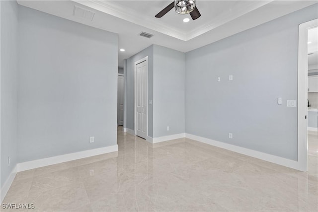 spare room featuring ceiling fan and a tray ceiling