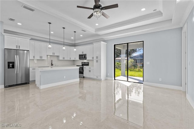 kitchen featuring stainless steel appliances, a raised ceiling, hanging light fixtures, and white cabinets