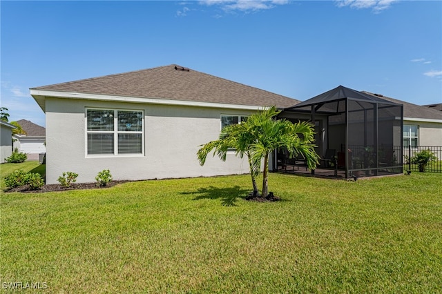 back of house featuring a lanai and a lawn