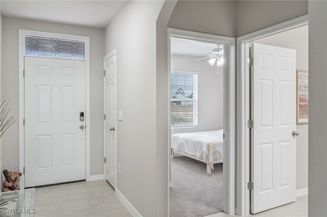 entryway featuring light colored carpet and ceiling fan