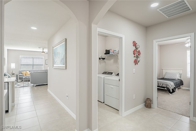 corridor with light tile patterned flooring and washer and dryer