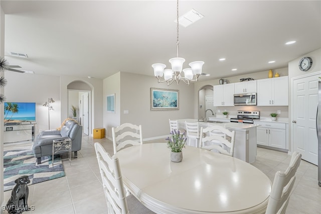 tiled dining area with sink and a chandelier