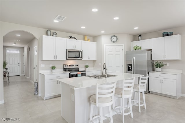 kitchen with an island with sink, white cabinetry, sink, a kitchen breakfast bar, and stainless steel appliances