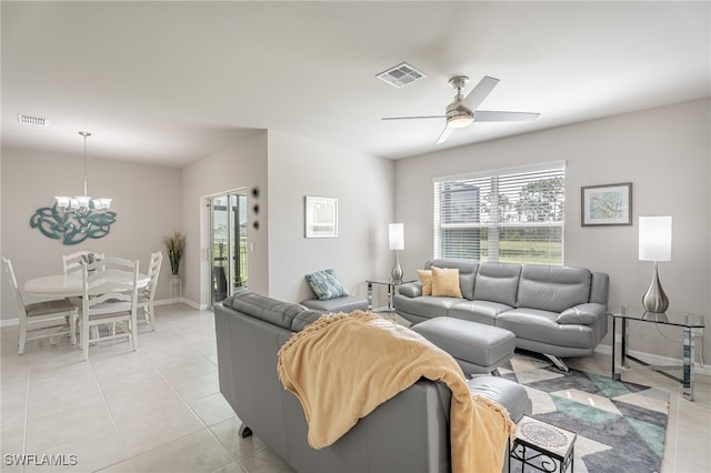 tiled living room with ceiling fan with notable chandelier