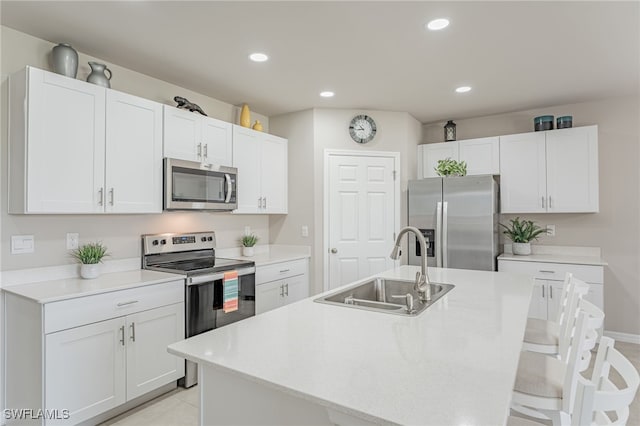 kitchen featuring white cabinetry, sink, a center island with sink, and appliances with stainless steel finishes