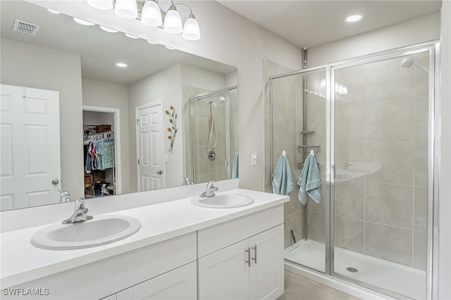 bathroom featuring tile patterned flooring, vanity, and walk in shower