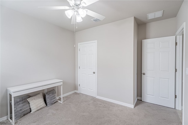 interior space with light carpet and ceiling fan