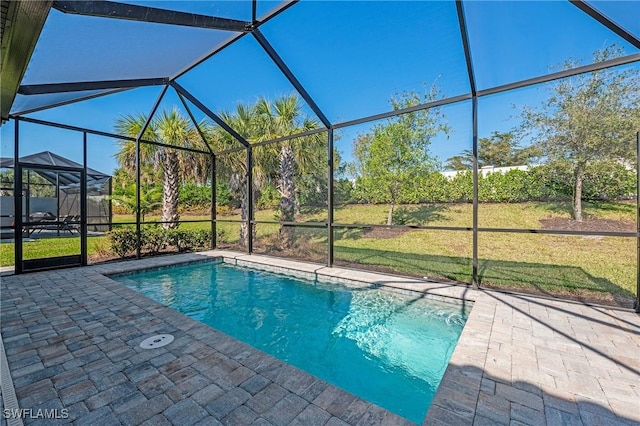 view of pool featuring a patio, glass enclosure, and a lawn