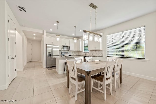 dining room featuring sink and light tile patterned floors