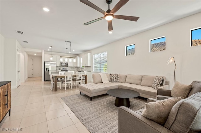 living room featuring light tile patterned floors and ceiling fan