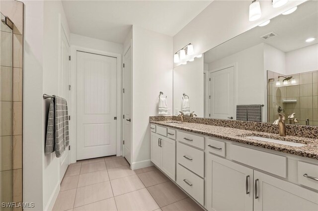 bathroom featuring tile patterned floors, a shower with shower door, and vanity