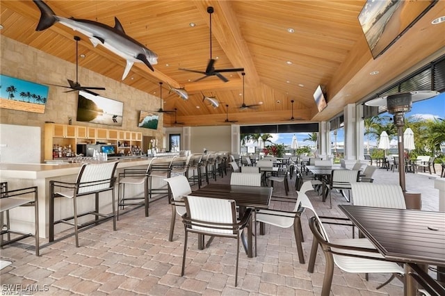 dining area featuring beam ceiling, wood ceiling, plenty of natural light, and high vaulted ceiling