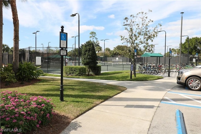 view of community with a yard and tennis court