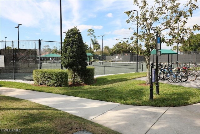 view of tennis court with a lawn