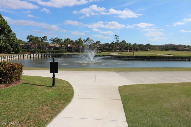 view of property's community with a yard and a water view