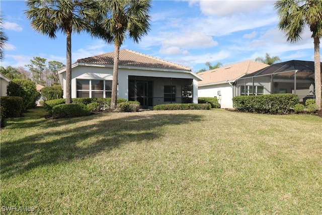 rear view of house featuring a yard and a lanai