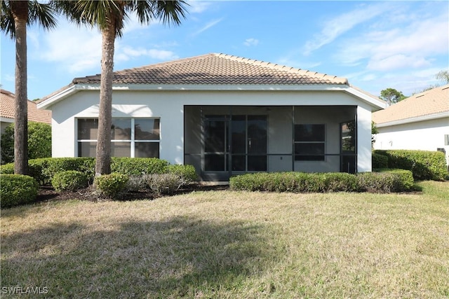 back of house with a sunroom and a yard