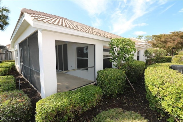 rear view of property featuring a sunroom