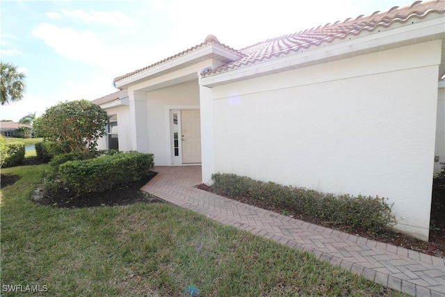 doorway to property with a lawn