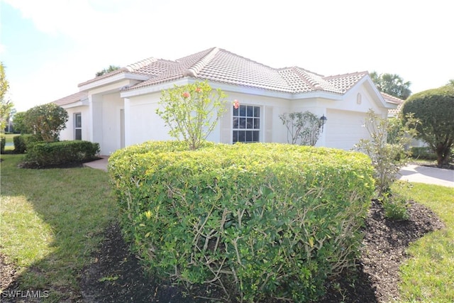 mediterranean / spanish-style home with a garage and a front yard