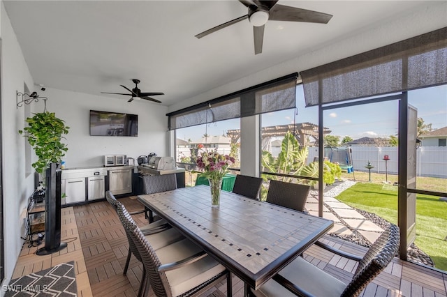 sunroom with ceiling fan and a healthy amount of sunlight