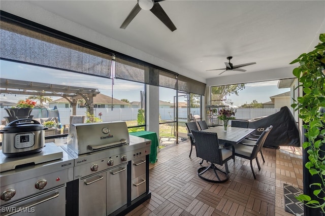 sunroom / solarium featuring ceiling fan