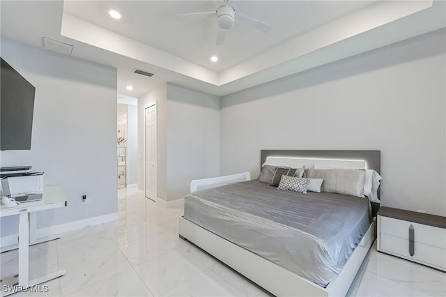 bedroom featuring a closet, ceiling fan, and a tray ceiling