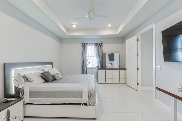 bedroom with ceiling fan and a tray ceiling