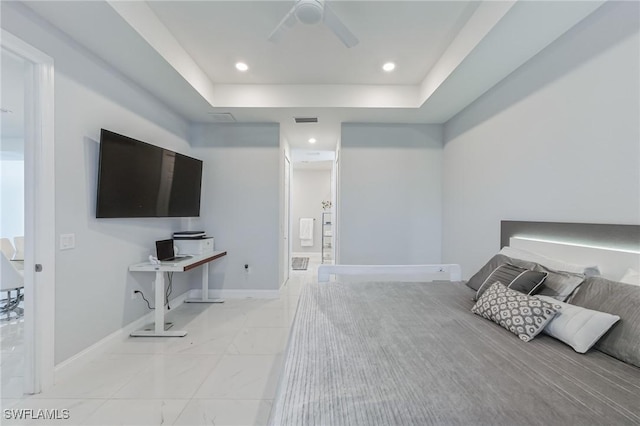 bedroom with ceiling fan and a tray ceiling