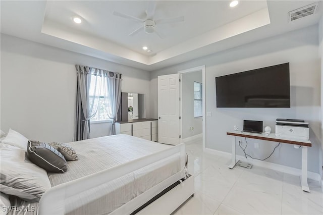 bedroom with ceiling fan and a tray ceiling