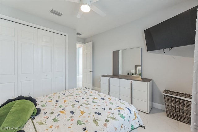 tiled bedroom featuring ceiling fan and a closet