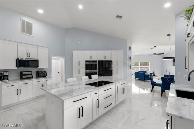 kitchen featuring hanging light fixtures, white cabinetry, light stone counters, and black appliances