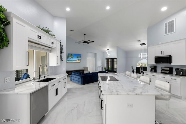 kitchen featuring a kitchen island, ceiling fan with notable chandelier, decorative light fixtures, sink, and white cabinets