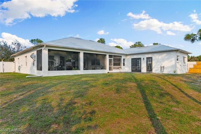 back of property featuring a lawn and a sunroom