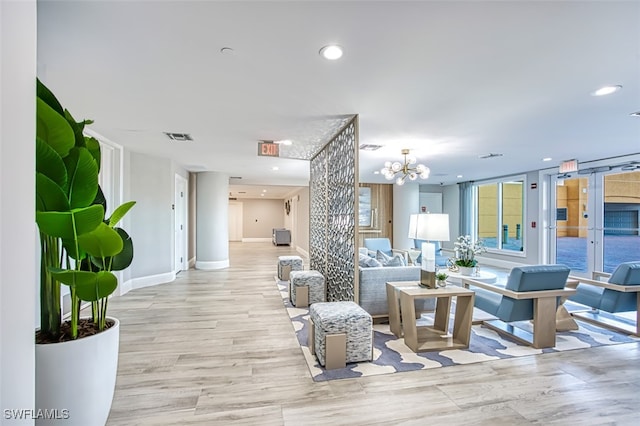 living room with an inviting chandelier and light hardwood / wood-style floors