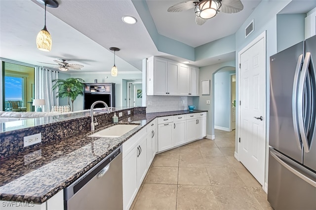 kitchen with sink, stainless steel appliances, hanging light fixtures, and white cabinets