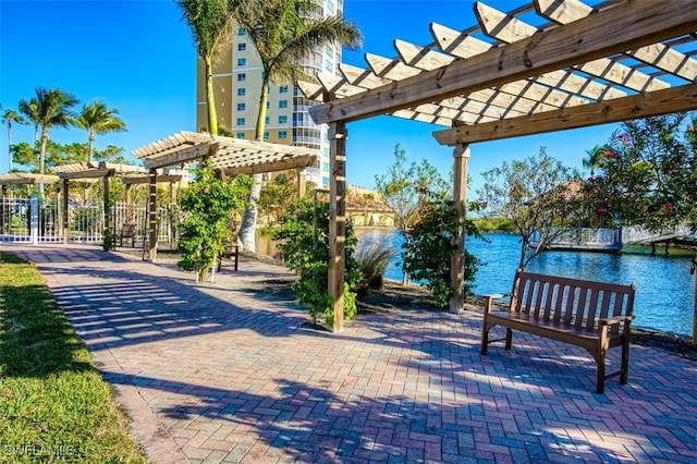 view of community featuring a water view and a pergola