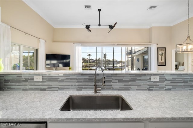 kitchen with sink, stainless steel dishwasher, hanging light fixtures, and a healthy amount of sunlight