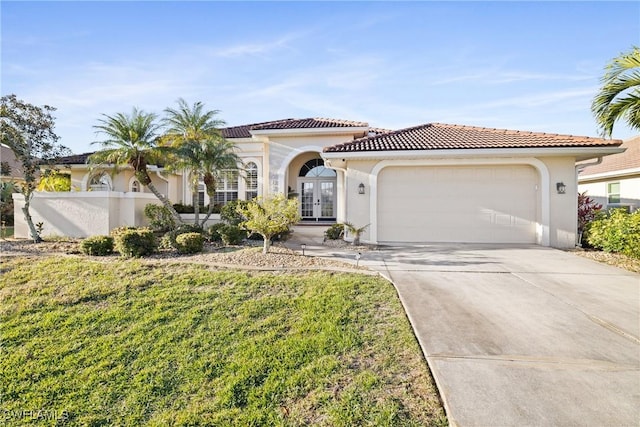 mediterranean / spanish-style home featuring a garage, a front lawn, and french doors