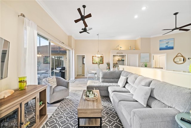 living room with crown molding, light hardwood / wood-style flooring, and ceiling fan