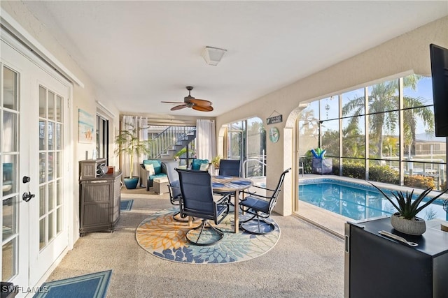 view of swimming pool with french doors, ceiling fan, a lanai, and a patio