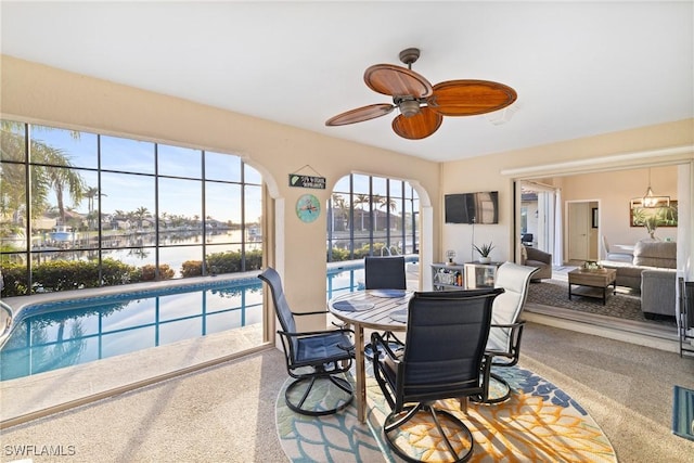 sunroom featuring a swimming pool and ceiling fan