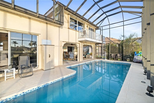 view of swimming pool featuring a patio area and glass enclosure