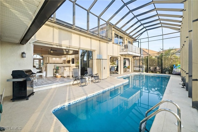 view of swimming pool featuring area for grilling, a lanai, and a patio area