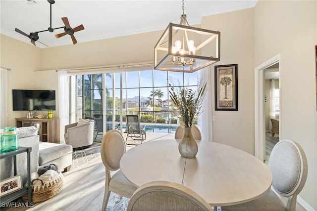 dining room with hardwood / wood-style floors, ornamental molding, and ceiling fan with notable chandelier