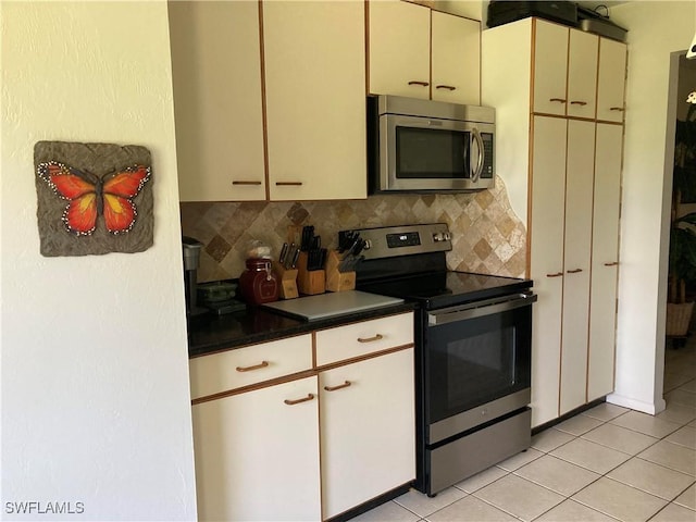 kitchen featuring light tile patterned floors, backsplash, and stainless steel appliances