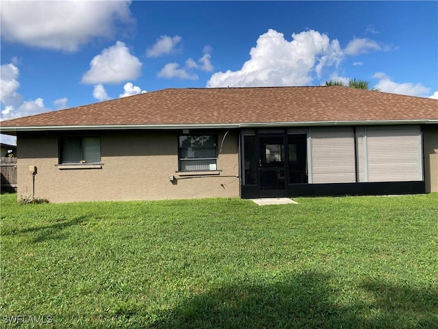 rear view of property featuring a lawn