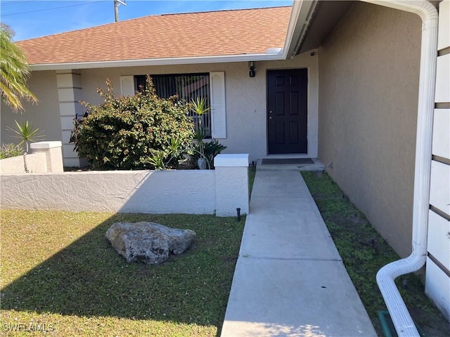 view of exterior entry with a yard