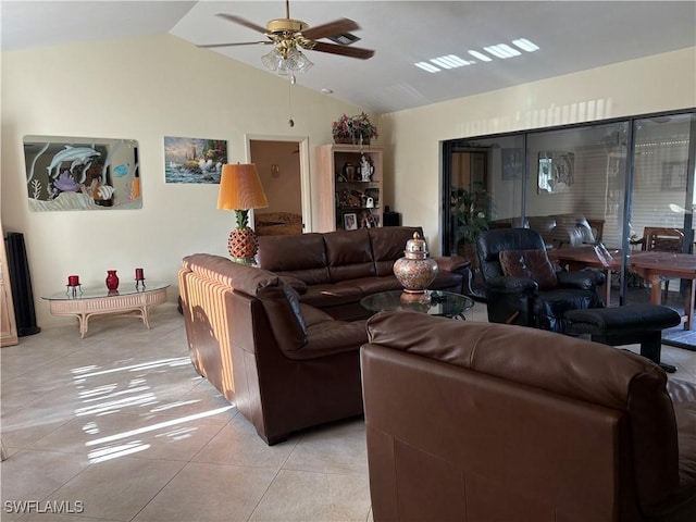 living room featuring lofted ceiling, light tile patterned flooring, and a ceiling fan