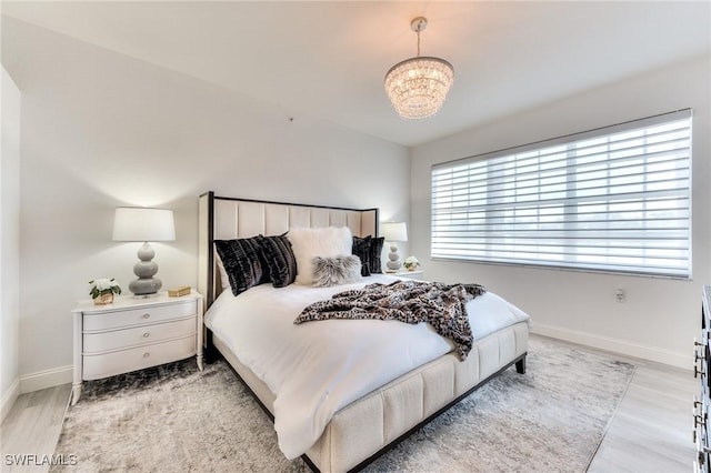 bedroom with light hardwood / wood-style floors and a chandelier